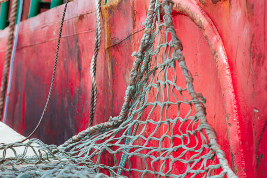 Rope tied to the hull of a boat moored in a harbor