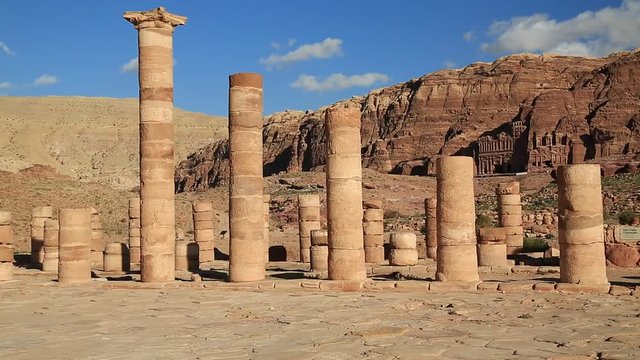 Columns of Great Temple in Petra - ancient historical and archaeological rock-cut city in Hashemite Kingdom of Jordan. Royal Tombs carved in the mountain on the background. UNESCO world heritage site