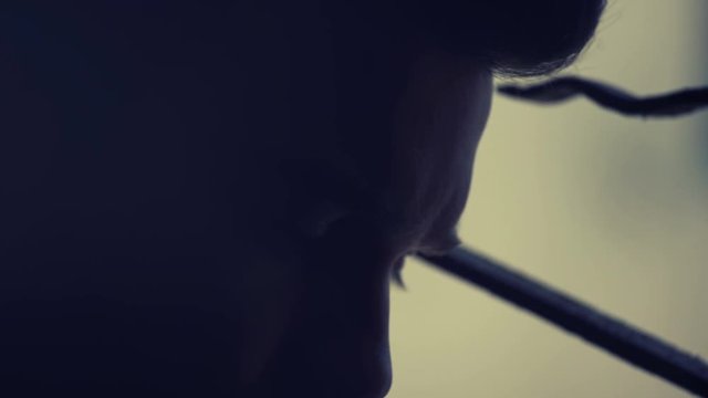 young man in twilight looks at the camera sadly