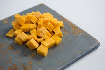 Cheddar cheese slices on cutting board