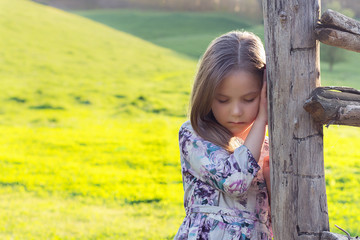 Smiling little girl with blond hair in a country side.