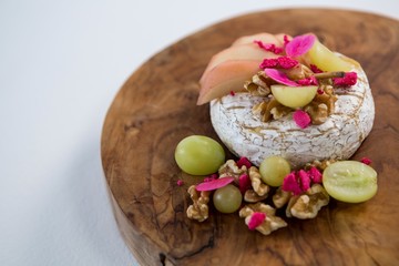 Brie cheese, grapes and nuts on wooden board 