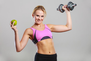 Diet fit body. Girl holds dumbbells and apple fruit