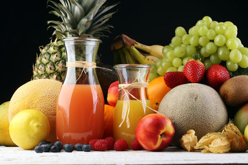 Apple and orange juice -several bottles with fruit and berry juices, vintage wooden background, selective focus