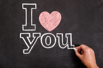 Black chalkboard with text I love you and hand
