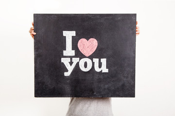 man holding black chalkboard with text I love you