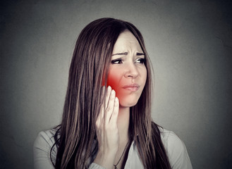 woman with sensitive toothache suffering from pain touching outside mouth .
