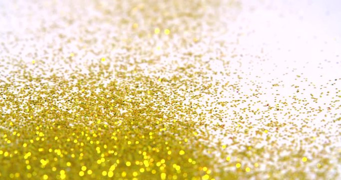 Series of glitter falling on a white background in slow motion.