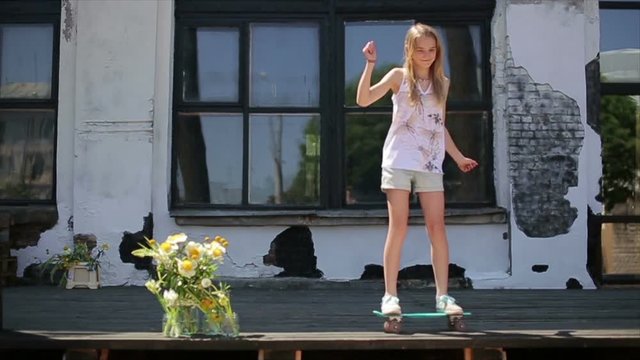female teen dancing on little skateboard