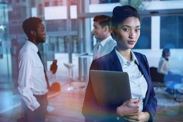 Obraz premium Portrait of businesswoman holding laptop