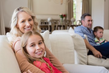 Smiling mother and daughter sitting together in living room