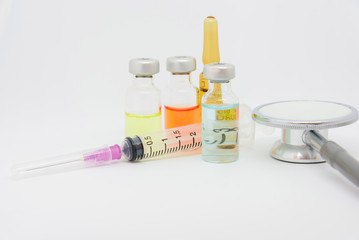 Close up syringe, vaccine and stethoscope on white background.