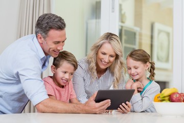 Family using digital tablet in kitchen