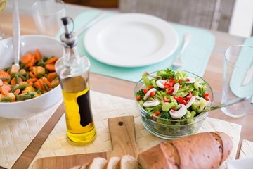 Bowl of salad and olive oil on dinning table