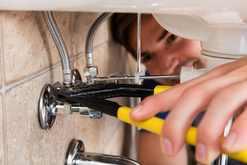 Male Plumber Installing Kitchen Sink