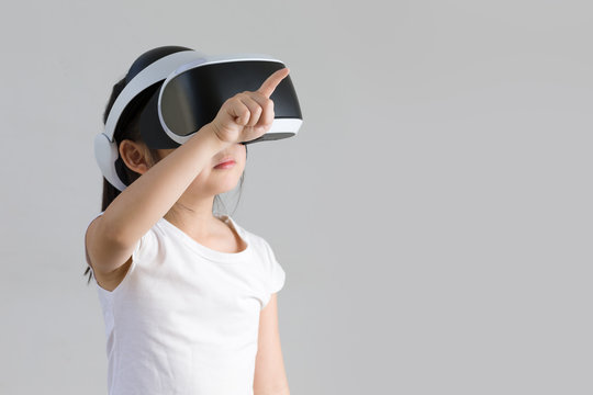 Child With Virtual Reality, VR, Headset Studio Shot Isolated On White Background. Kid Exploring Digital Virtual World With VR Goggles.