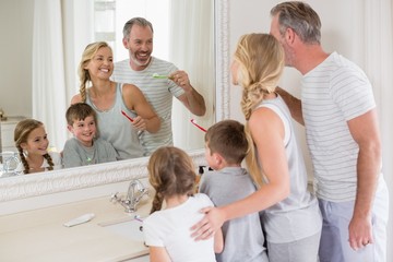 Parents and kids brushing teeth in bathroom