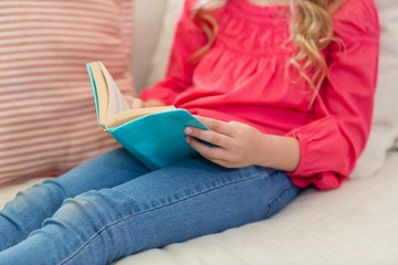 Girl reading a book on sofa in living room