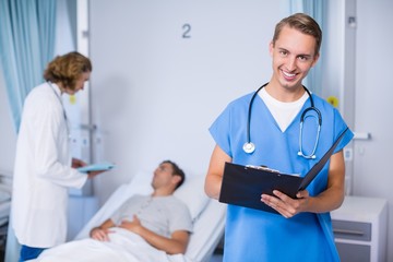 Portrait of doctor writing on clipboard