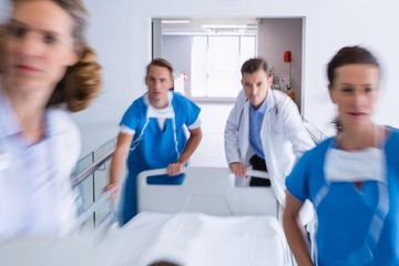 Obraz na płótnie Canvas Doctors pushing emergency stretcher bed in corridor