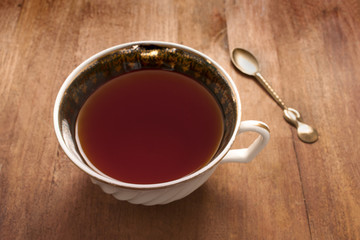 Vintage tea cup with spoon on wooden table