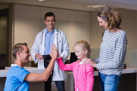 Doctor giving high five to girl