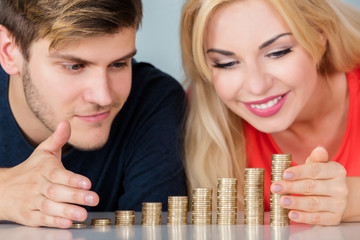 Couple Saving Pile Of Coins