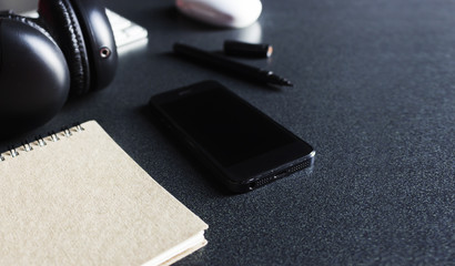 stationary and office equipment on wood table with film colors tone and soft-focus in the background. over light