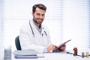 Portrait of male doctor using digital tablet
