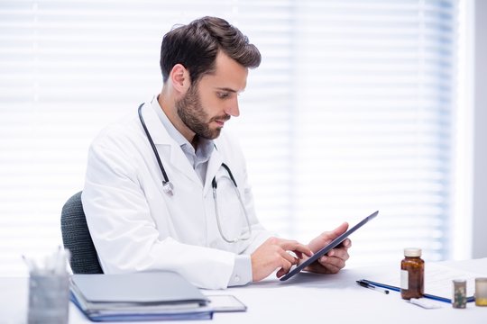 Male doctor using digital tablet