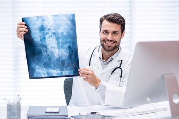 Portrait of male doctor examining x-ray