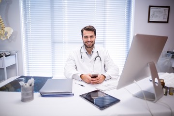 Fototapeta premium Portrait of male doctor sitting at desk