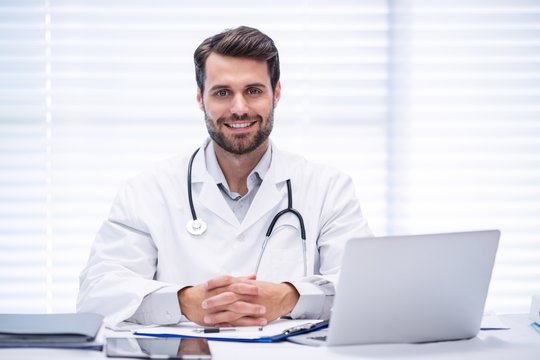 Portrait of male doctor sitting at desk
