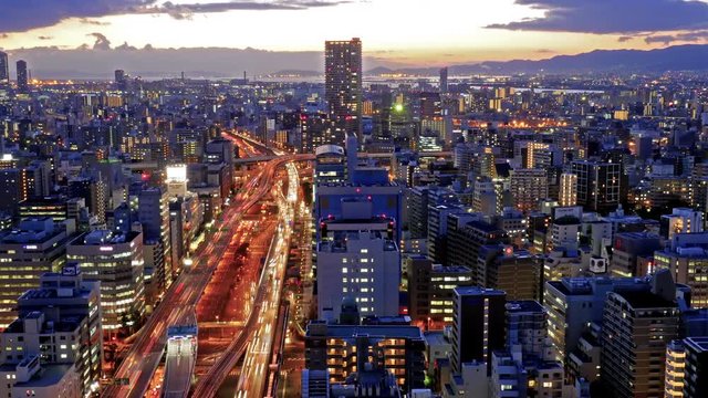 Time-lapse of Osaka traffic car trails and illuminated building
