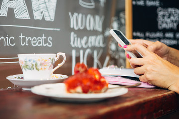 Hands using cell in cafe