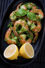 Closeup of tiger shrimps served with chimichurri sauce and lemon