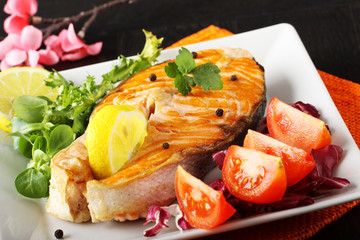 Slice of fresh salmon with tomatoes and salad