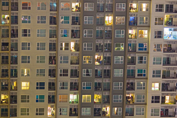 Apartment windows at night showing a vibrant community of condos