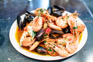 Shrimp, crayfish and mussels are on the big dish in the sauce.