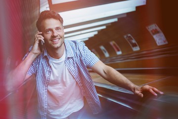 Handsome man using mobile phone on escalator