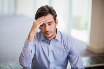 Worried businessman with hand on head