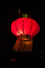 Happy chinese new year concept: traditional red paper lanterns hanging. Illuminated street decorations lightning in the night.