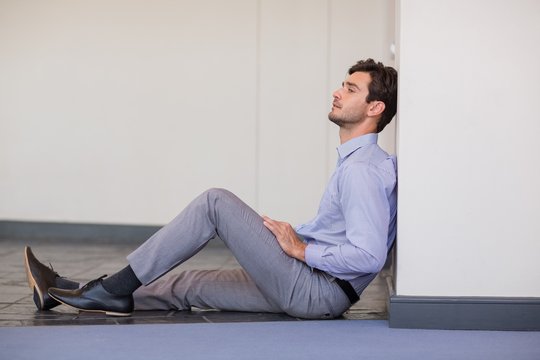 Worried Businessman Sitting On Floor