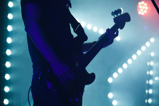 Bass guitar player in blue stage lights