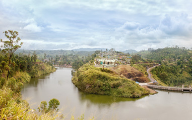 Fototapeta na wymiar Dam on a river and houses on a hill in Sri lanka