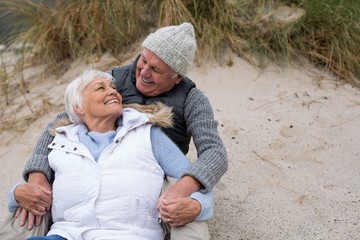 Senior couple sitting together on beach