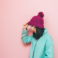 Pensive girl in the fashion pose and winter clothing in pastel colors