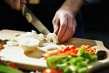 Chef cuts onion with a knife