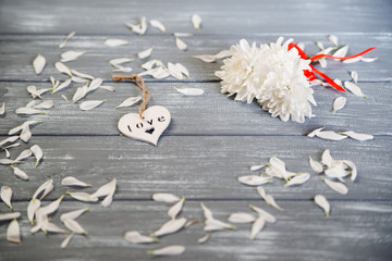 Happy Valentines Day background. Decorative white wooden heart on grey rustic, whith flowers,...