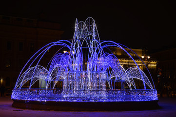 Светящийся фонтан - иллюминация на улице города.